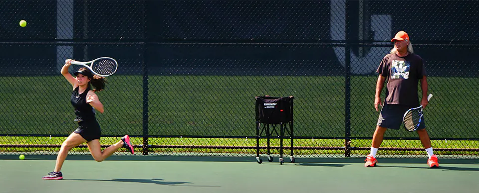 Coach watching athlete play at College Tennis Exposure Camp